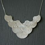 Inspired by silhouettes of Filipino embroidered fans. Sterling silver.