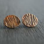 Roundish bark studs. Thick gauge brass with sterling silver posts. Finished with a heat patina for subtle color. $32.00