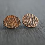 Roundish bark studs. Thick gauge brass with sterling silver posts. Finished with a heat patina for subtle color. $52.00